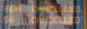 Female bus driver with LED display showing cancelled over the top